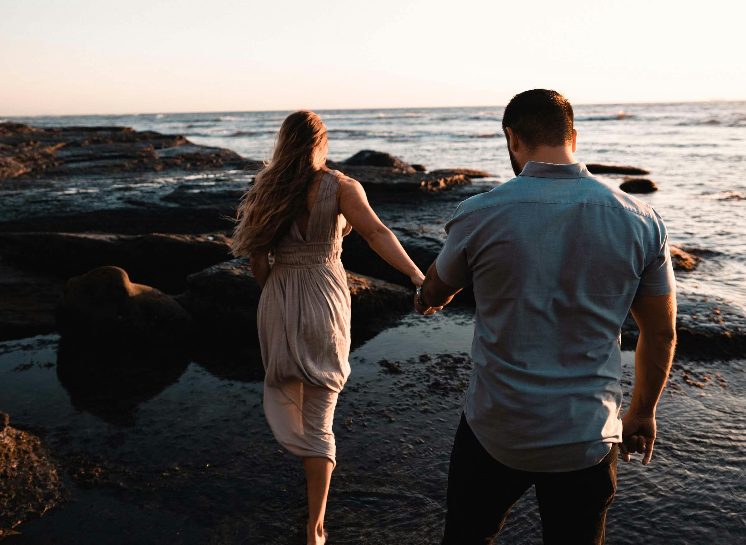 couple-in-love-walking-hand-in-hand-under-the-sunset-at-sea